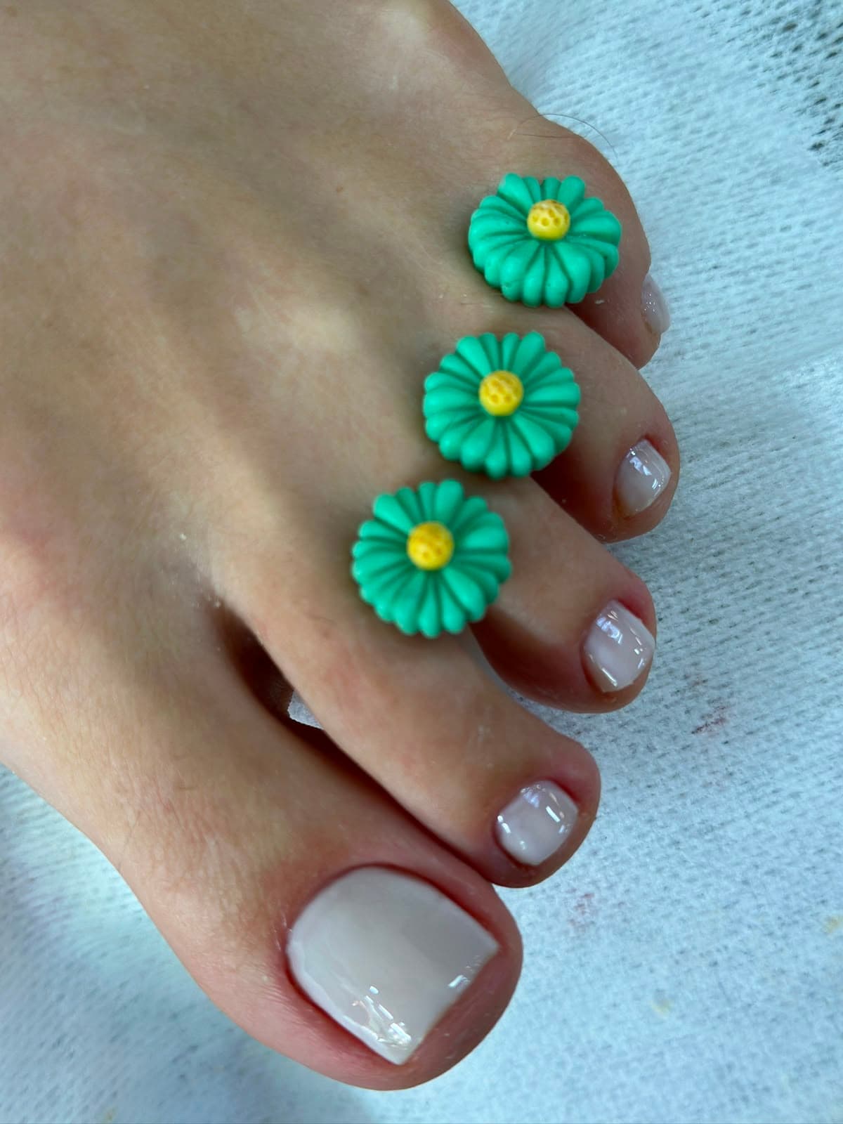 Pedicure nude com separadores florais